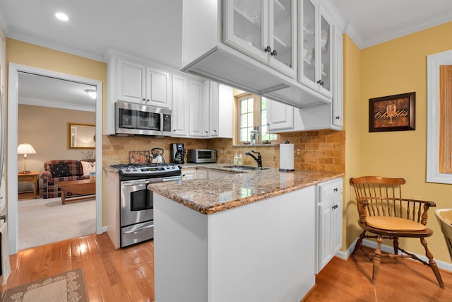 4112 Adams Dr, Shelby Twp, MI 48316 - kitchen with stainless steel appliances, light wood-style flooring, white cabinets, ornamental molding, and light stone counters