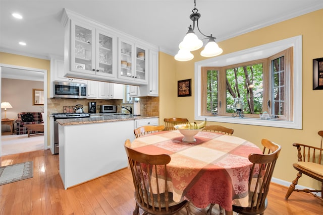 4112 Adams Dr, Shelby Twp, MI 48316 - dining area featuring light wood-style floors, crown molding, recessed lighting, and a chandelier