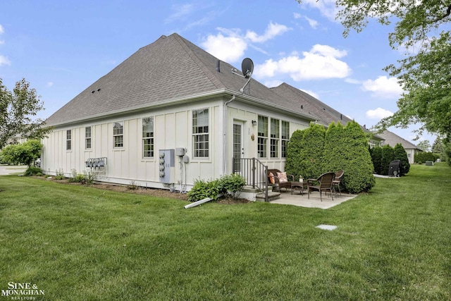 32 River Ln, Grosse Pointe Woods, MI 48236 - back of property featuring board and batten siding, a shingled roof, a patio area, and a yard
