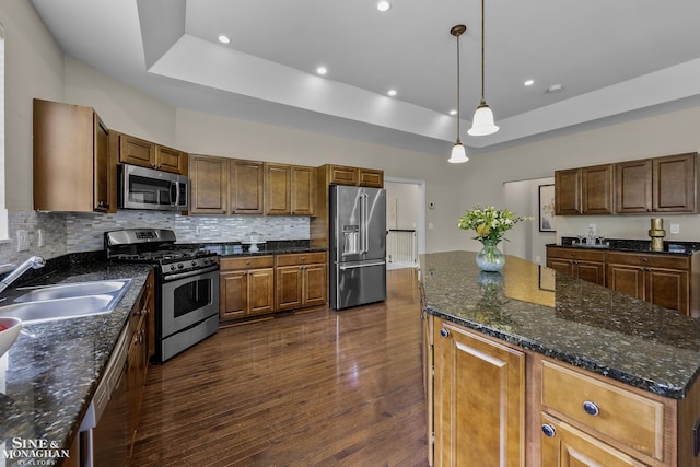 32 River Ln, Grosse Pointe Woods, MI 48236 - kitchen with stainless steel appliances, a tray ceiling, a center island, dark wood finished floors, and backsplash