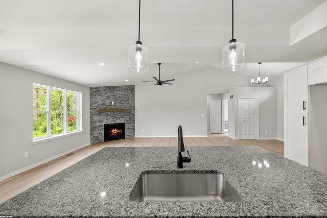 36217 Little Mack Ave, Clinton Township, MI 48035 - kitchen with light wood finished floors, light stone counters, open floor plan, a stone fireplace, and lofted ceiling