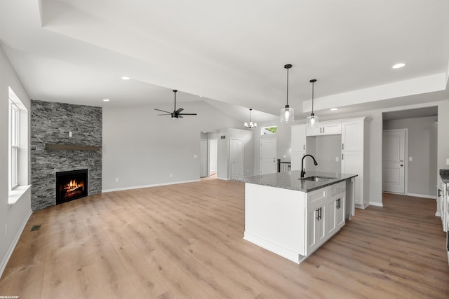 36217 Little Mack Ave, Clinton Township, MI 48035 - kitchen featuring ceiling fan, dark stone countertops, white cabinets, light wood finished floors, and a stone fireplace