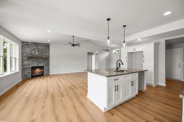 36217 Little Mack Ave, Clinton Township, MI 48035 - kitchen with light wood-style floors, white cabinetry, dark stone counters, ceiling fan, and decorative light fixtures
