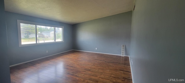 113 Albatross St, Gwinn, MI 49841 - spare room featuring a textured ceiling and dark wood-style flooring