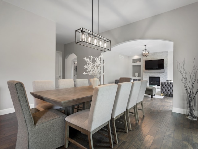 4661 Applewood Ct, Rochester, MI 48306 - dining space with arched walkways, dark wood finished floors, a fireplace, and a chandelier