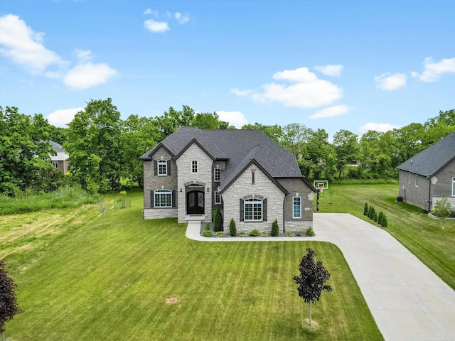 4661 Applewood Ct, Rochester, MI 48306 - french country style house with stone siding, concrete driveway, a front yard, a shingled roof, and view of wooded area