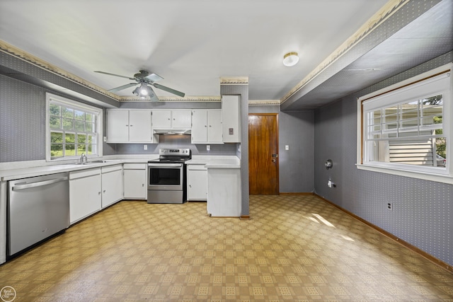 5541 Houghten Dr, Troy, MI 48098 - kitchen featuring stainless steel appliances, wallpapered walls, light countertops, under cabinet range hood, and white cabinets