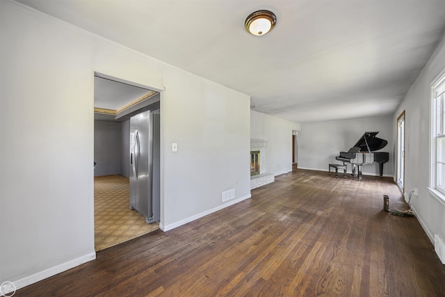 5541 Houghten Dr, Troy, MI 48098 - unfurnished living room with wood finished floors and a brick fireplace