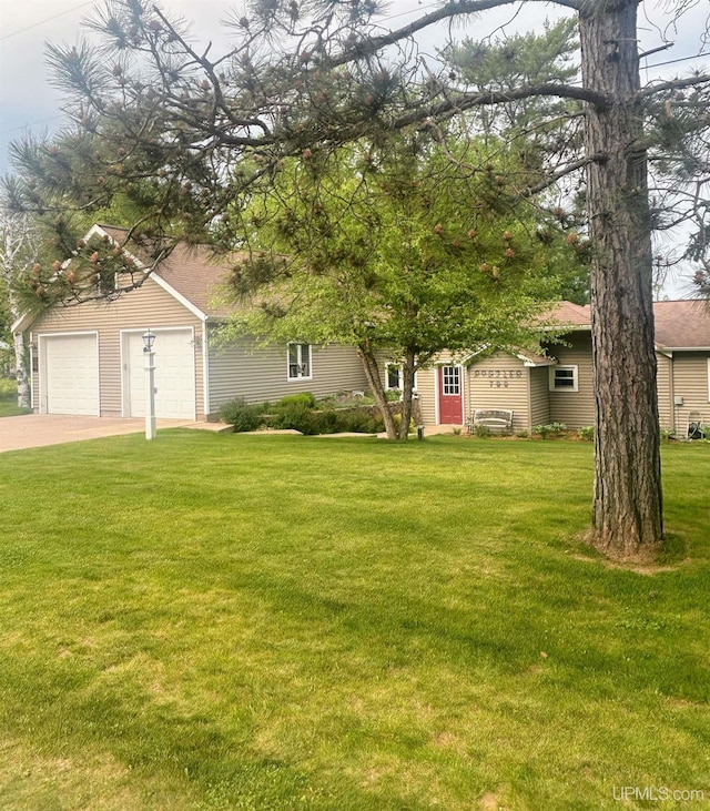 790 N Horseshoe Lake Dr, Gwinn, MI 49841 - obstructed view of property featuring a garage, a front lawn, and concrete driveway