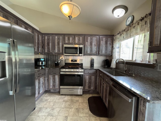 51767 Huntley Ave, New Baltimore, MI 48047 - kitchen with appliances with stainless steel finishes, lofted ceiling, dark brown cabinetry, tasteful backsplash, and dark stone countertops