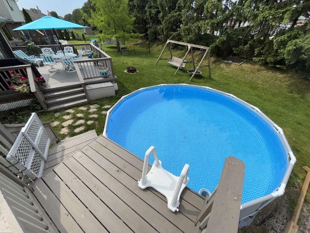 51767 Huntley Ave, New Baltimore, MI 48047 - outdoor pool featuring a lawn, a wooden deck, and a playground