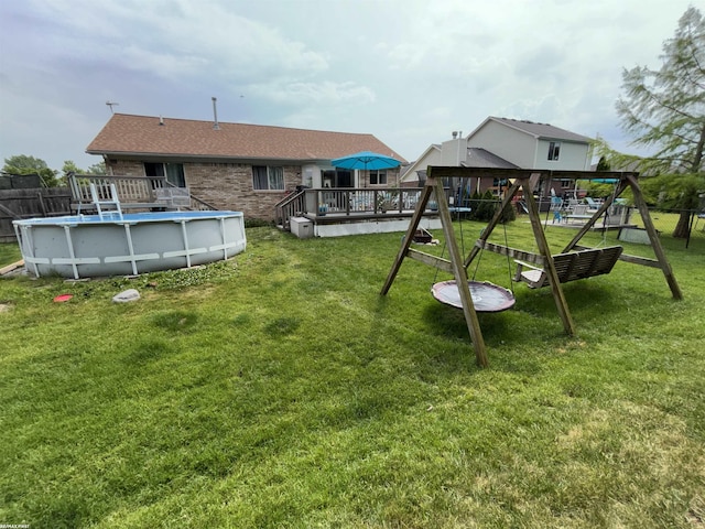 51767 Huntley Ave, New Baltimore, MI 48047 - view of yard featuring a wooden deck, a playground, and an outdoor pool