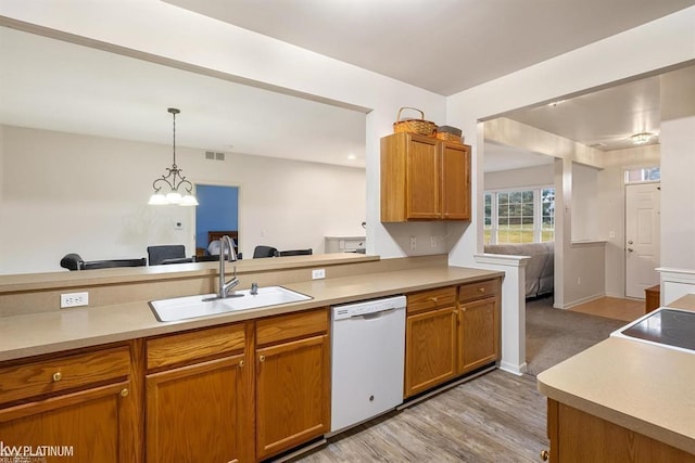 45592 Warwick Dr, Macomb Twp, MI 48044 - kitchen with white dishwasher, light countertops, brown cabinetry, decorative light fixtures, and light wood-style flooring