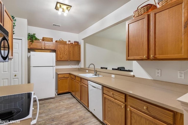 45592 Warwick Dr, Macomb Twp, MI 48044 - kitchen with white appliances, light countertops, light wood-type flooring, and brown cabinets