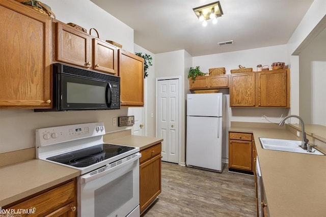 45592 Warwick Dr, Macomb Twp, MI 48044 - kitchen with white appliances, light wood-style flooring, light countertops, and brown cabinets