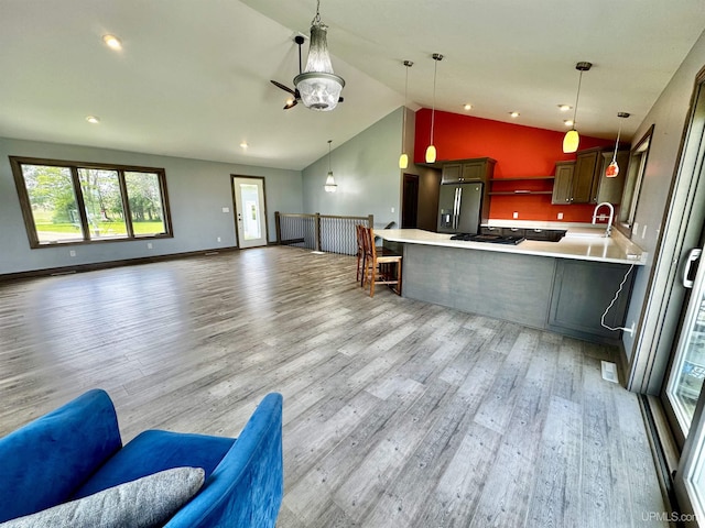 1084 15.5 Rd, Bark River, MI 49807 - kitchen with stainless steel fridge with ice dispenser, open floor plan, vaulted ceiling, light wood finished floors, and healthy amount of natural light