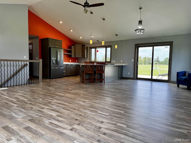1084 15.5 Rd, Bark River, MI 49807 - kitchen with stainless steel fridge with ice dispenser, open floor plan, open shelves, light countertops, and wood finished floors