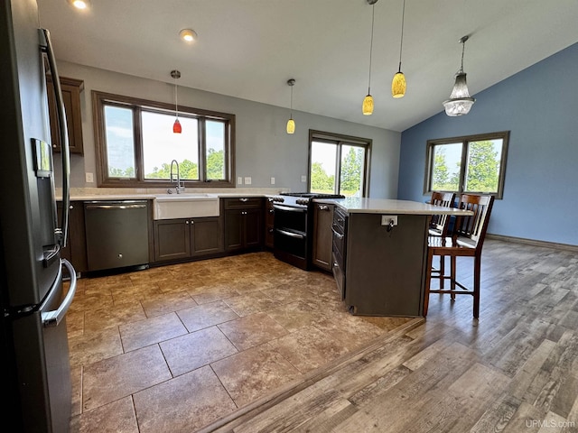 1084 15.5 Rd, Bark River, MI 49807 - kitchen with appliances with stainless steel finishes, light countertops, a kitchen bar, lofted ceiling, and pendant lighting