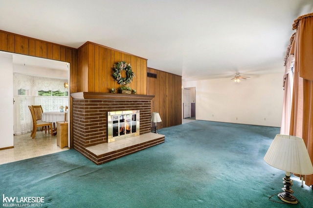 3480 Devonshire St, Sterling Heights, MI 48310 - living room featuring wood walls, carpet, ceiling fan, and a fireplace