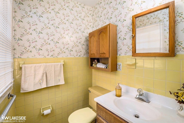 3480 Devonshire St, Sterling Heights, MI 48310 - bathroom with wallpapered walls, vanity, tile walls, and wainscoting