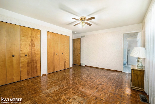 3480 Devonshire St, Sterling Heights, MI 48310 - unfurnished bedroom with multiple closets, connected bathroom, a ceiling fan, and wallpapered walls