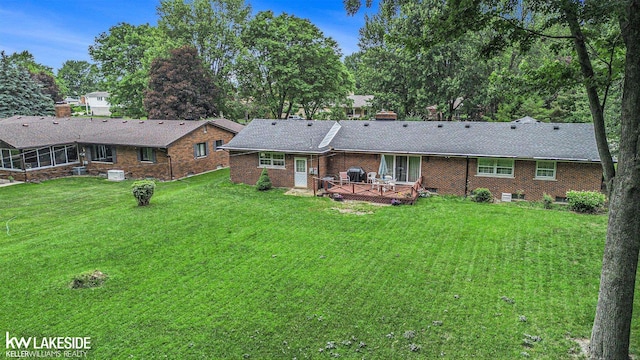 3480 Devonshire St, Sterling Heights, MI 48310 - back of property with a deck, a lawn, brick siding, roof with shingles, and a chimney