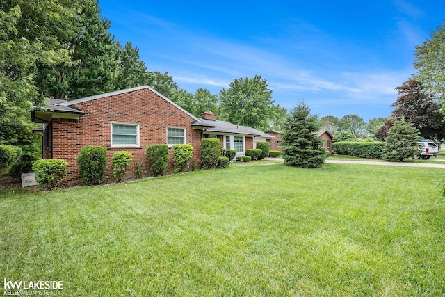 3480 Devonshire St, Sterling Heights, MI 48310 - view of front of house with brick siding, a front lawn, and a chimney