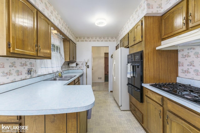 3480 Devonshire St, Sterling Heights, MI 48310 - kitchen featuring wallpapered walls, black appliances, a warming drawer, light countertops, and brown cabinetry