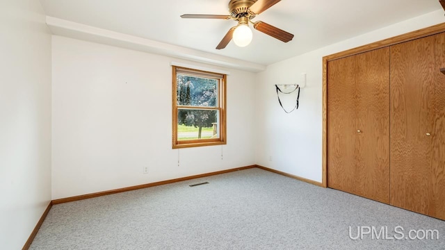 160 N Pyle Dr, Kingsford, MI 49802 - unfurnished bedroom with carpet flooring, a closet, and a ceiling fan