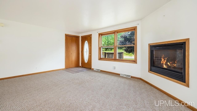 160 N Pyle Dr, Kingsford, MI 49802 - unfurnished living room featuring a glass covered fireplace and light carpet