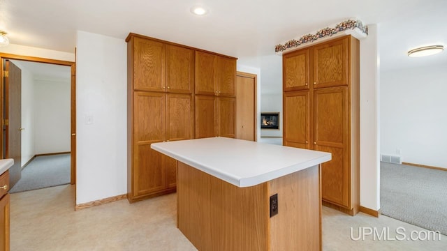 160 N Pyle Dr, Kingsford, MI 49802 - kitchen featuring light carpet, brown cabinetry, a kitchen island, and recessed lighting