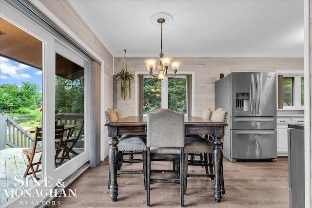 2727 Horseshoe Lake Rd, West Branch, MI 48661 - dining area with ornamental molding, a chandelier, light wood-style flooring, plenty of natural light, and wood walls
