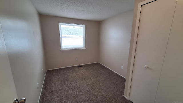 4130 Elmhurst Rd, Waterford, MI 48328 - empty room featuring a textured ceiling and dark colored carpet