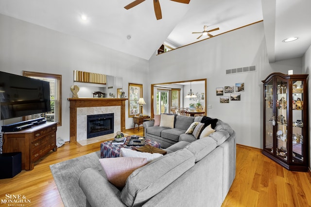 23875 Settlers Dr, Macomb Twp, MI 48042 - living area with ceiling fan, a fireplace, light wood-type flooring, and high vaulted ceiling