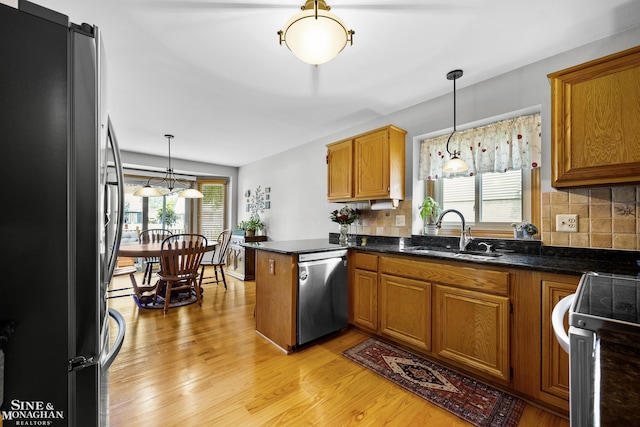 23875 Settlers Dr, Macomb Twp, MI 48042 - kitchen featuring freestanding refrigerator, dishwasher, brown cabinetry, and a peninsula