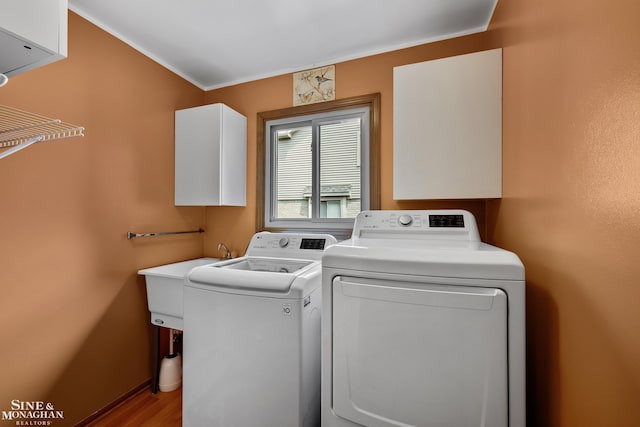 23875 Settlers Dr, Macomb Twp, MI 48042 - laundry area with washer and clothes dryer, wood finished floors, crown molding, and cabinet space