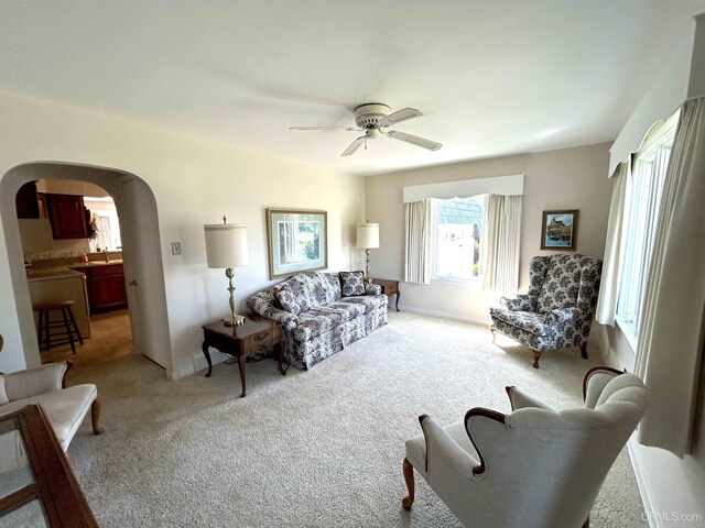 2010 Deer Lake Ave, Ishpeming, MI 49849 - living room with arched walkways, ceiling fan, and light colored carpet