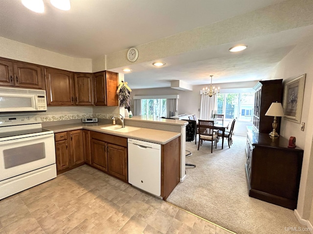 2010 Deer Lake Ave, Ishpeming, MI 49849 - kitchen with white appliances, a peninsula, a chandelier, light countertops, and hanging light fixtures
