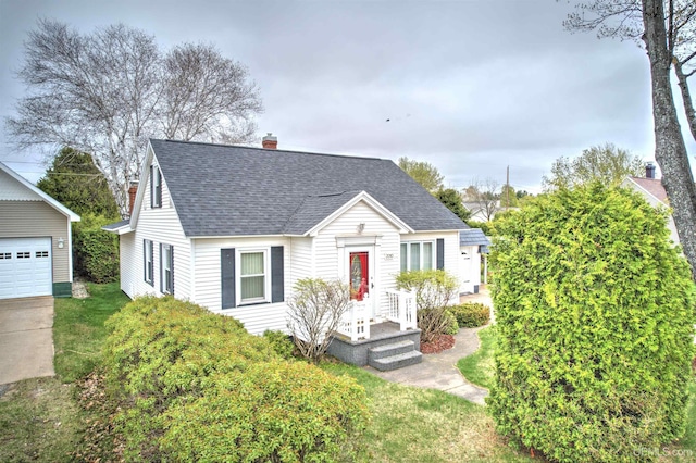 2010 Deer Lake Ave, Ishpeming, MI 49849 - view of front of home with a shingled roof, a chimney, an outdoor structure, a garage, and a front yard