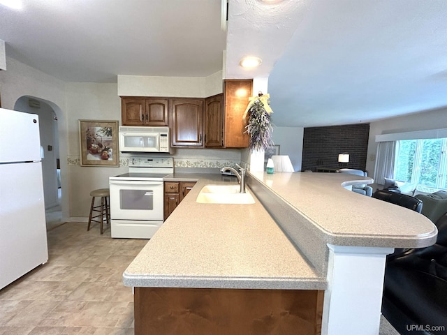 2010 Deer Lake Ave, Ishpeming, MI 49849 - kitchen with white appliances, light countertops, a peninsula, open floor plan, and arched walkways