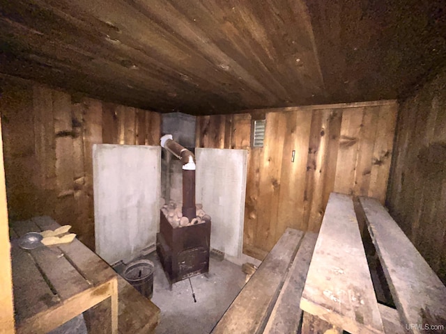 2010 Deer Lake Ave, Ishpeming, MI 49849 - misc room featuring wooden ceiling, wooden walls, unfinished concrete floors, and a wood stove