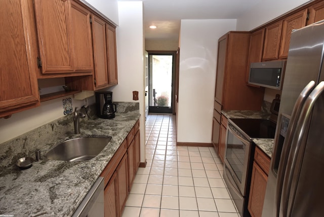131 Cherryl Ln Unit 4, Algonac, MI 48001 - kitchen featuring stainless steel appliances, light tile patterned flooring, brown cabinetry, light stone countertops, and recessed lighting