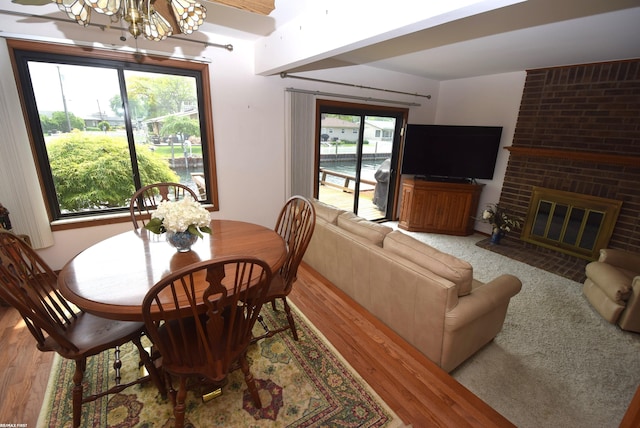 131 Cherryl Ln Unit 4, Algonac, MI 48001 - dining room with a chandelier, light wood-style flooring, and a brick fireplace