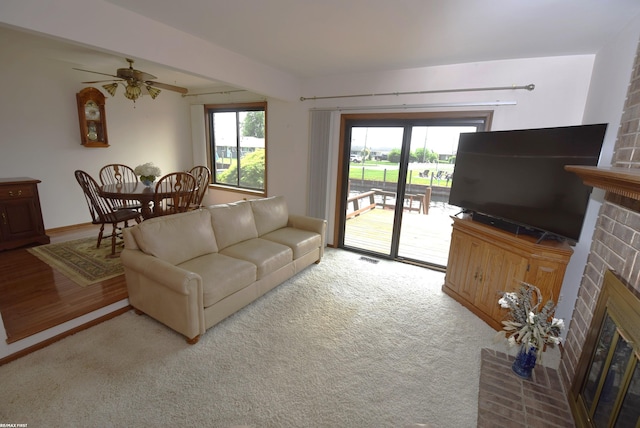 131 Cherryl Ln Unit 4, Algonac, MI 48001 - living room featuring a brick fireplace, a ceiling fan, and light colored carpet