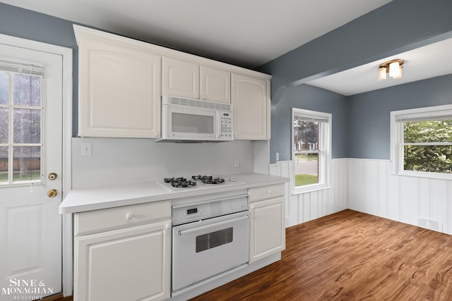 1284 Brys Dr, Grosse Pointe Woods, MI 48236 - kitchen with white appliances, wainscoting, white cabinetry, dark wood-type flooring, and light countertops