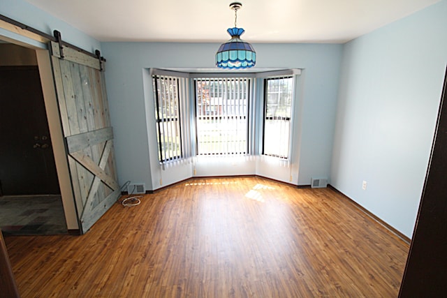 48501 E Ranch Dr, Chesterfield Twp, MI 48051 - spare room with a barn door and wood finished floors