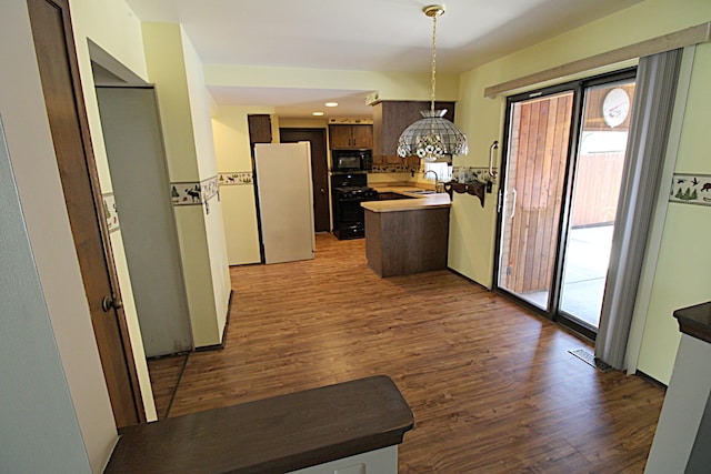 48501 E Ranch Dr, Chesterfield Twp, MI 48051 - kitchen with black appliances, wood finished floors, a peninsula, and hanging light fixtures