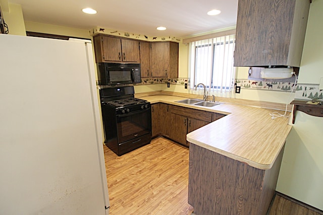 48501 E Ranch Dr, Chesterfield Twp, MI 48051 - kitchen featuring black appliances, light countertops, light wood finished floors, a peninsula, and recessed lighting