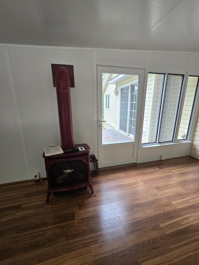 10505 N Athey Ave, Harrison, MI 48625 - unfurnished living room featuring a wood stove and wood finished floors