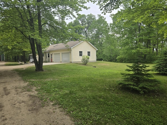 10505 N Athey Ave, Harrison, MI 48625 - view of property exterior featuring driveway, a garage, and a lawn